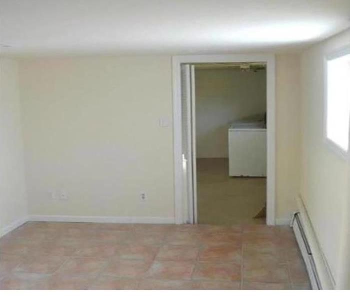 a white walled living room that is empty but looks like new