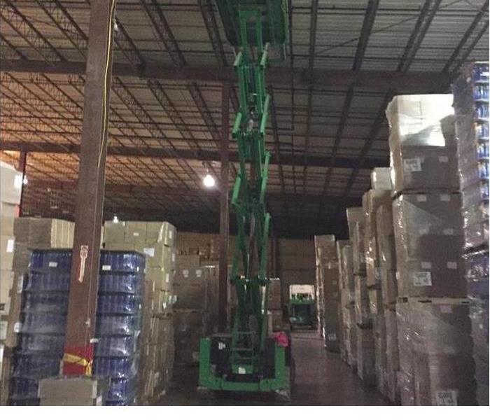 a warehouse in Chicago after SERVPRO had begun the cleanup and repair with a SERVPRO lift machine in the picture 