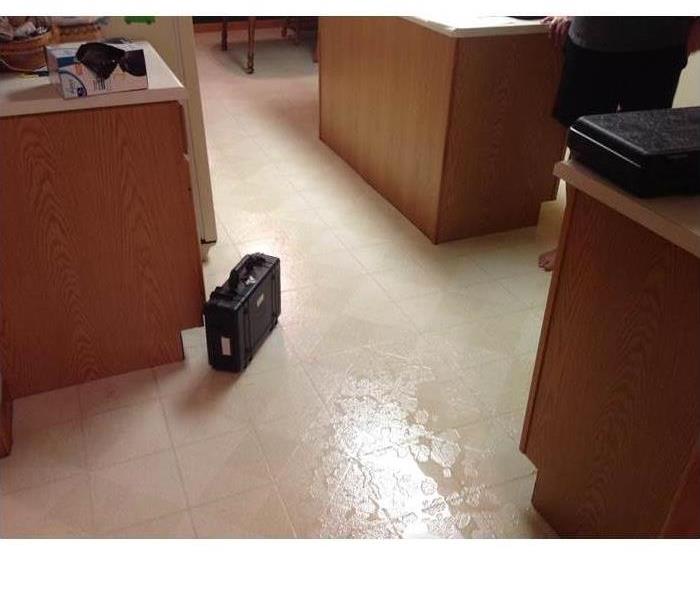 a kitchen with water damage visible on the ground 